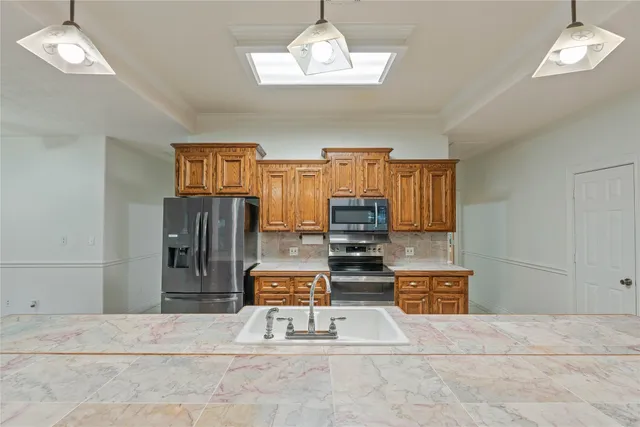 a living room with furniture a chandelier and a dining table with wooden floor