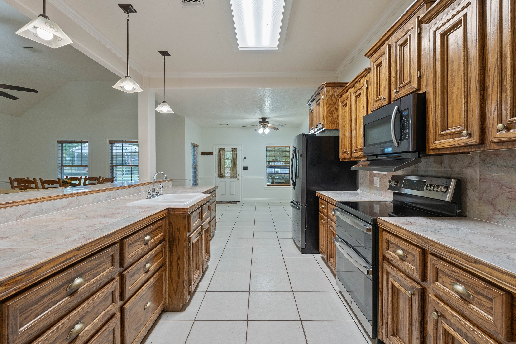 600 Hughes Loop Willis, TX 77378 - Photo 13 of 50 a kitchen with stainless steel appliances granite countertop a sink a stove and a wooden cabinets