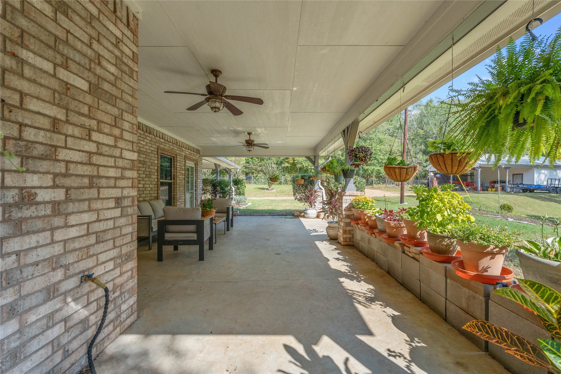 600 Hughes Loop Willis, TX 77378 - Photo 30 of 50 a view of a patio with a table and chairs and potted plants