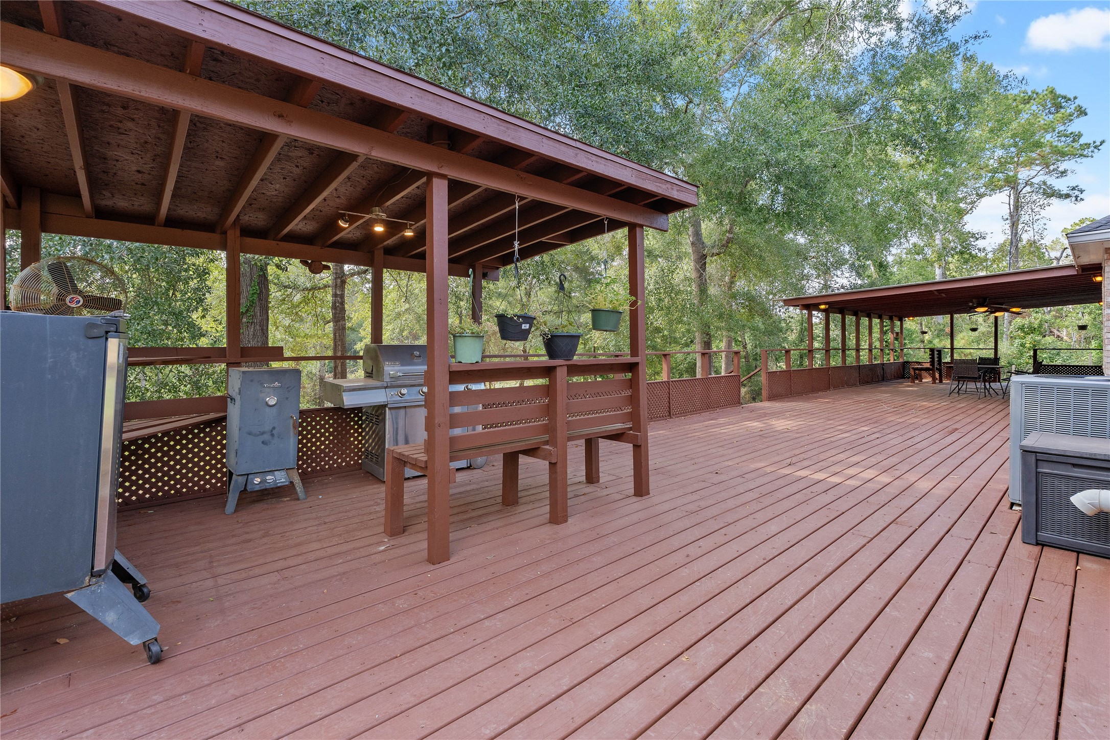 600 Hughes Loop Willis, TX 77378 - Photo 32 of 50 a patio with wooden floor a yard a table and chairs