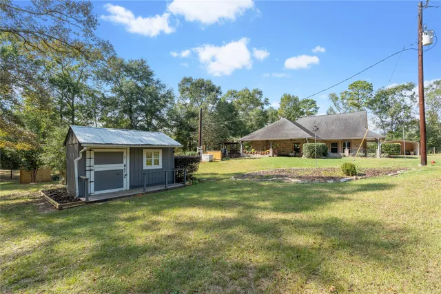 a view of a house with backyard and a tree