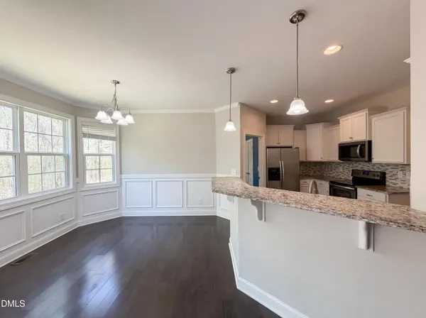 a view of a kitchen with kitchen island a counter space a sink appliances and cabinets