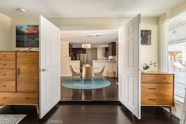 a view of a hallway with wooden floor and cabinet