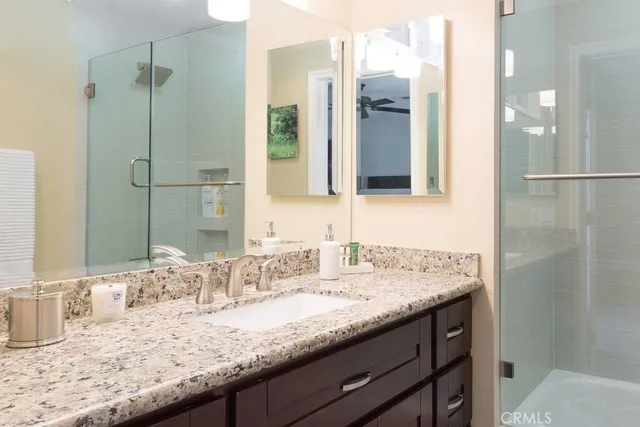 a bathroom with a granite countertop sink and a mirror