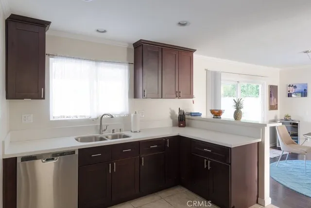 a kitchen with a sink dishwasher a stove and cabinets