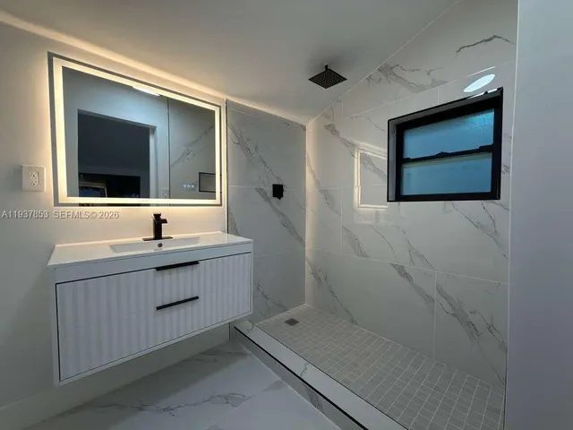 a bathroom with a sink a mirror and a shower