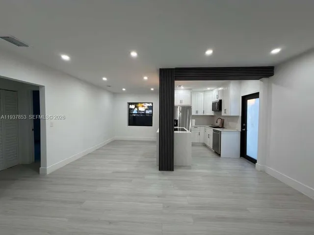 a view of kitchen with refrigerator sink and stove