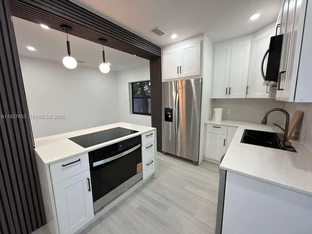 a kitchen with a refrigerator and a sink