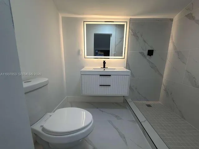 a bathroom with a sink a toilet and mirror