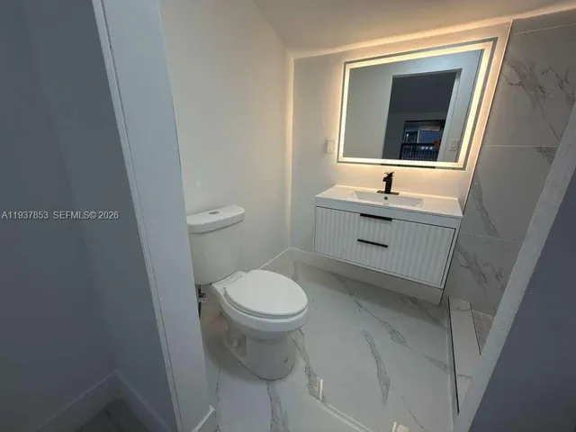 a bathroom with a sink toilet and mirror