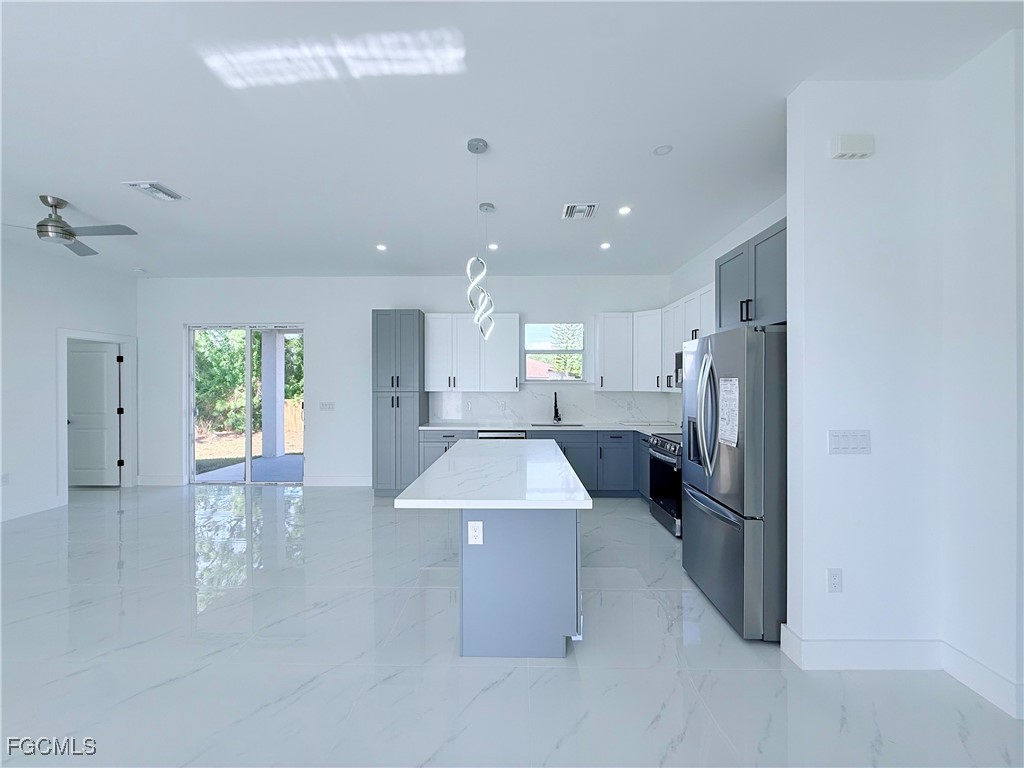 4006 2nd Street Southwest Lehigh Acres, FL 33976 - Photo 11 of 29 an open kitchen with a refrigerator and a sink