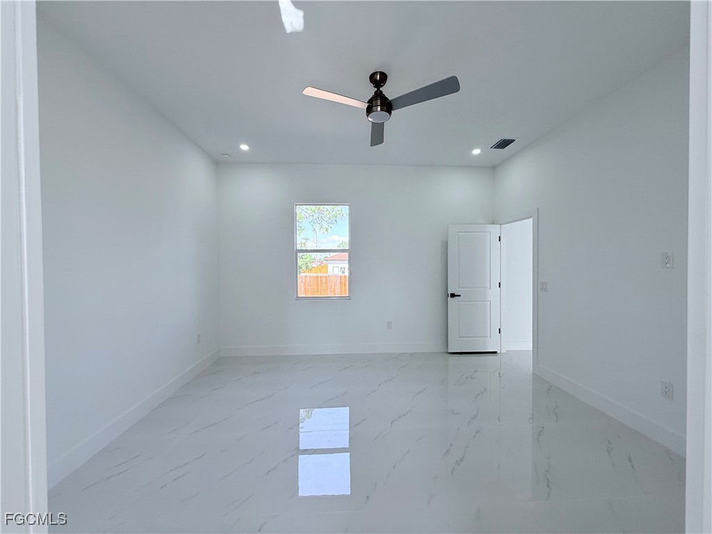 4006 2nd Street Southwest Lehigh Acres, FL 33976 - Photo 13 of 29 an empty room with windows and fan
