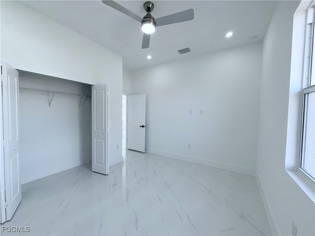 4006 2nd Street Southwest Lehigh Acres, FL 33976 - Photo 22 of 29 an empty room with a ceiling fan and a window