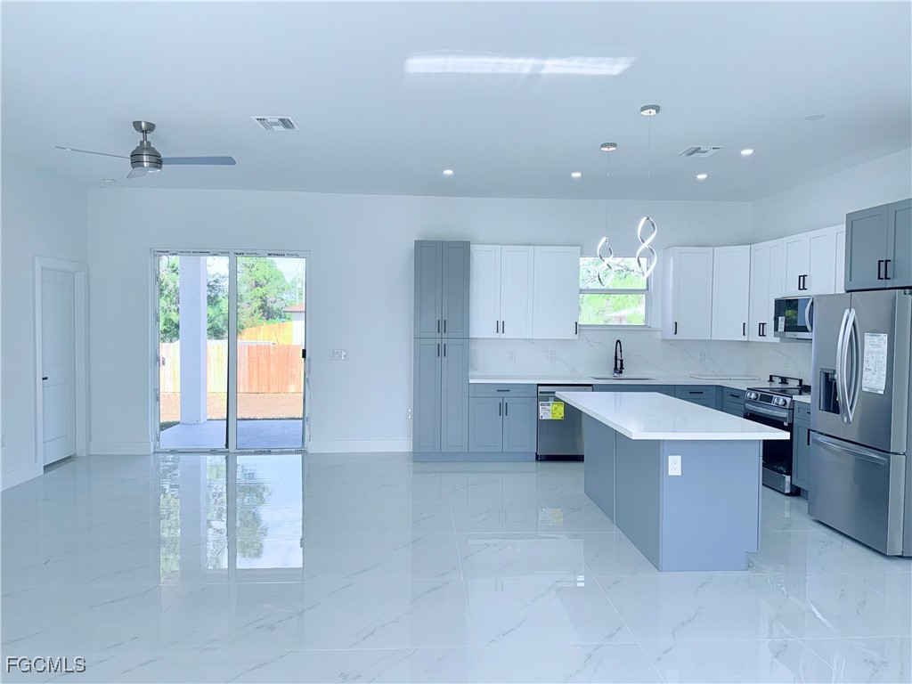 4006 2nd Street Southwest Lehigh Acres, FL 33976 - Photo 3 of 29 a large kitchen with a large window in it and stainless steel appliances