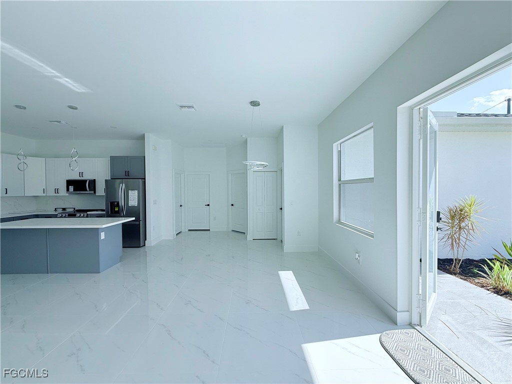 4006 2nd Street Southwest Lehigh Acres, FL 33976 - Photo 5 of 29 a large white kitchen with a refrigerator a stove a sink and a window