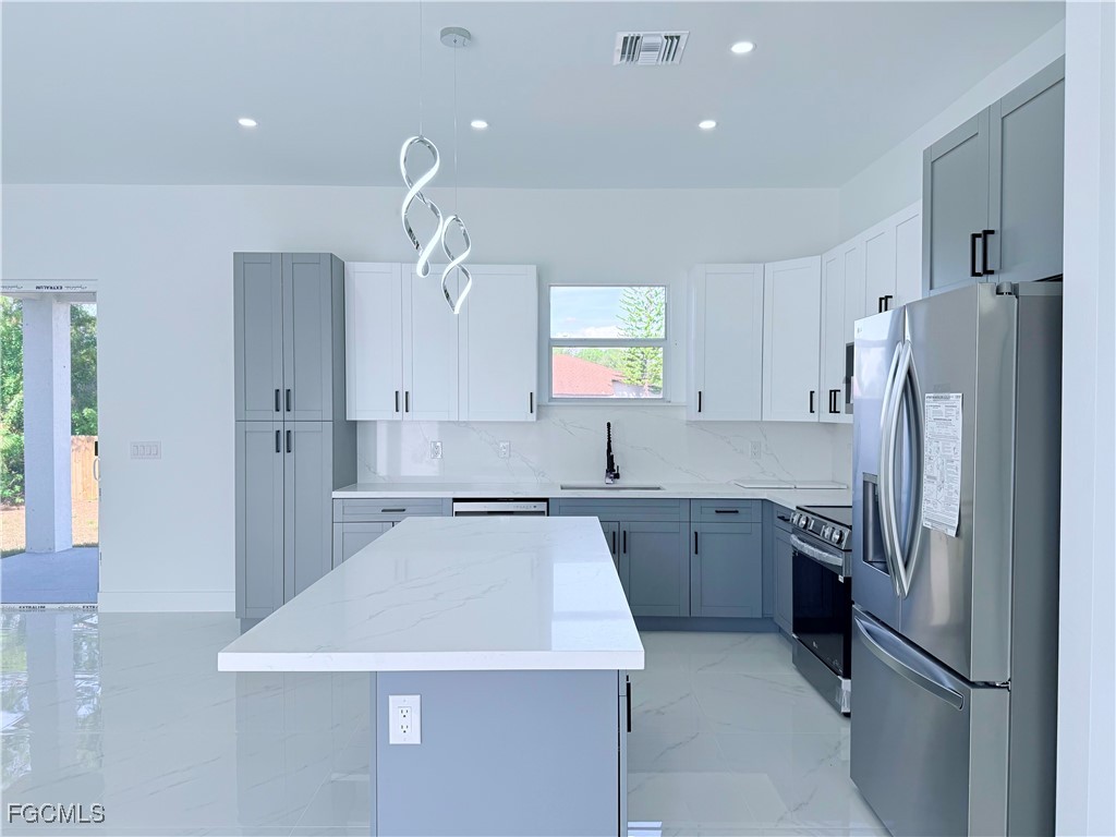 4006 2nd Street Southwest Lehigh Acres, FL 33976 - Photo 8 of 29 a kitchen with a refrigerator a sink and dishwasher