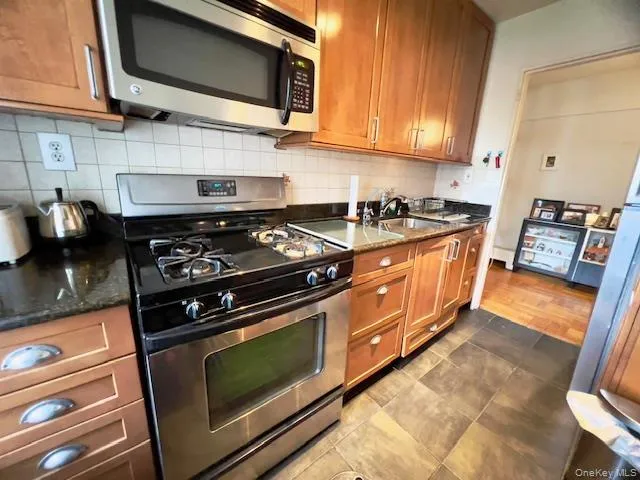 a kitchen with stainless steel appliances granite countertop a stove and a microwave