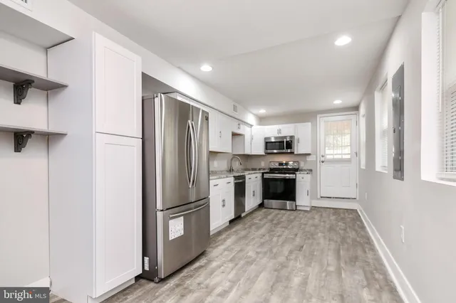 a kitchen with a refrigerator and a stove top oven