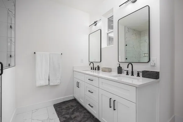 a bathroom with double vanity sink and a mirror
