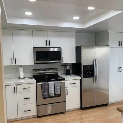 a kitchen with stainless steel appliances kitchen island granite countertop a stove a refrigerator and a microwave