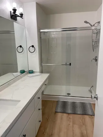a bathroom with a granite countertop shower sink and vanity
