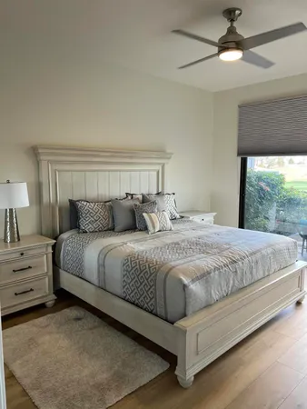 a large bed sitting in a bedroom next to a window