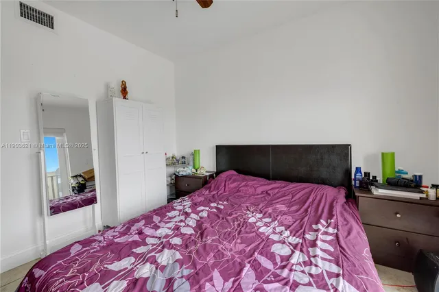 a bedroom with a bed and a view of kitchen