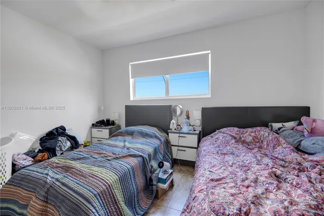 a bedroom with two beds and a lamp