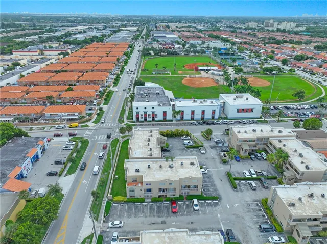 an aerial view of residential houses with outdoor space and ocean view