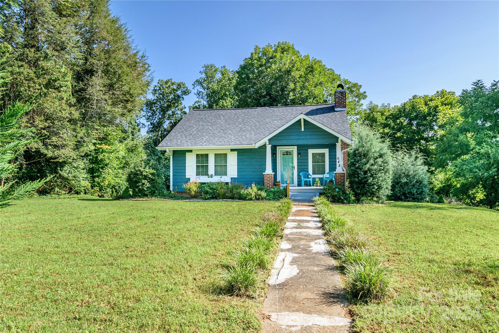 648 Chimney Rock Road Rutherfordton, NC 28139 - Photo 1 of 43 a front view of a house with a yard and trees