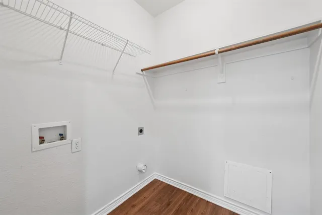 a view of a livingroom with a fireplace a ceiling fan and wooden floor