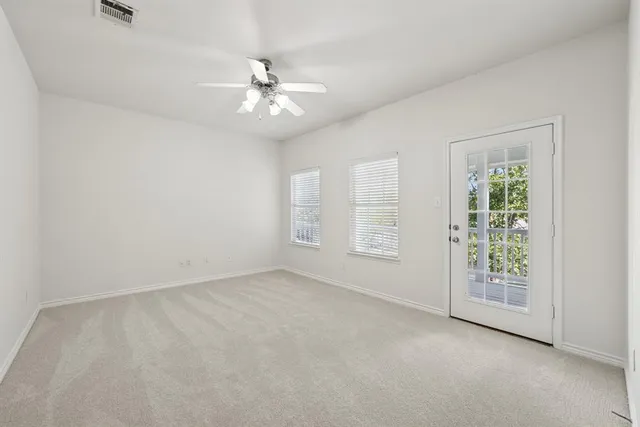 an empty room with chandelier fan and closet area