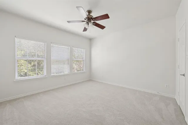 an empty room with a window and a fan