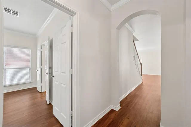 a view of a hallway with wooden floor and entryway