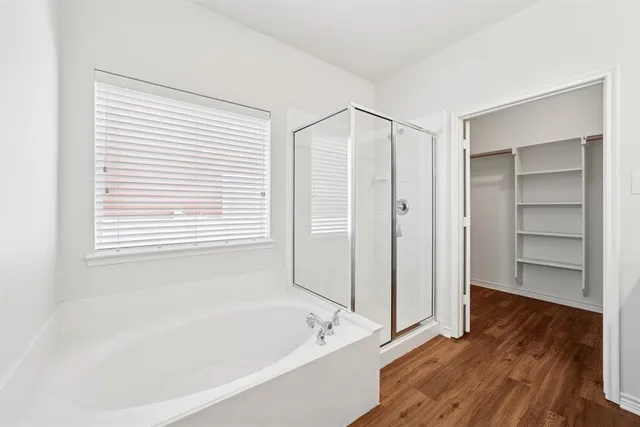 a bathroom with a bathtub and a walk in closet