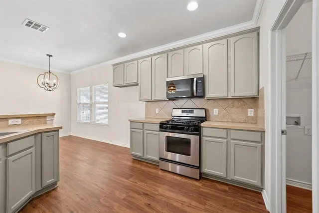 a kitchen with stainless steel appliances granite countertop a stove a sink and a microwave