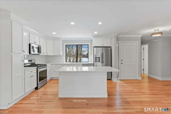 a large kitchen with stainless steel appliances granite countertop a large counter top and a stove top oven