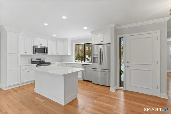 a kitchen with stainless steel appliances granite countertop a refrigerator stove microwave and sink