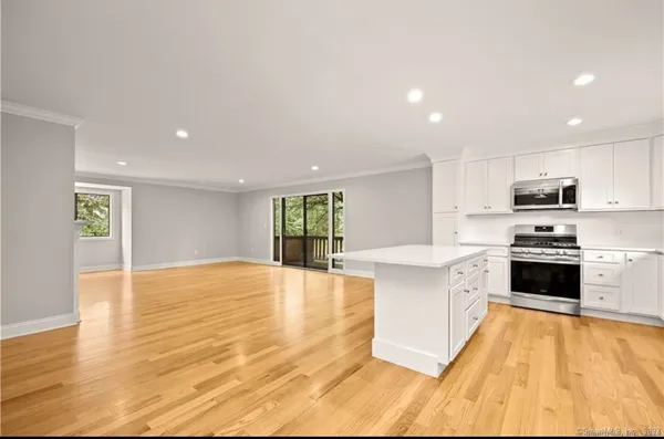 a large kitchen with stainless steel appliances granite countertop a stove a sink and a refrigerator