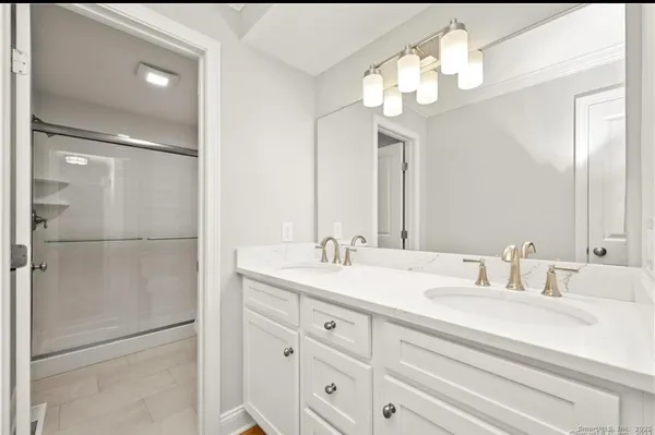 a bathroom with a double vanity sink and a mirror