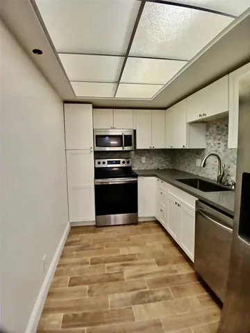 a kitchen with granite countertop a stove and refrigerator