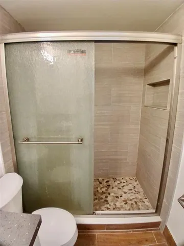 a bathroom with a sink a toilet a shower and a mirror
