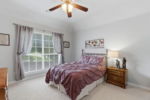 a bed sitting in a bedroom next to a window