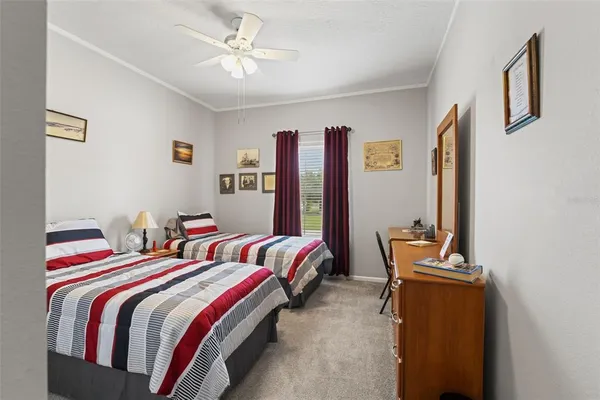a bedroom with two beds and a desk