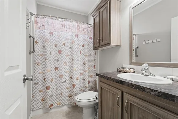 a bathroom with a granite countertop sink a toilet and a mirror