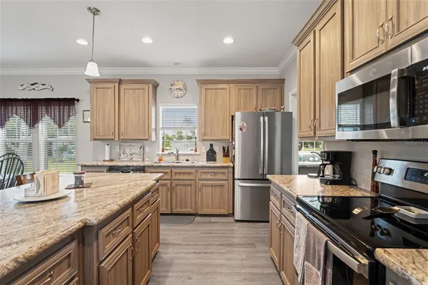 a kitchen with stainless steel appliances granite countertop a stove refrigerator sink and cabinets