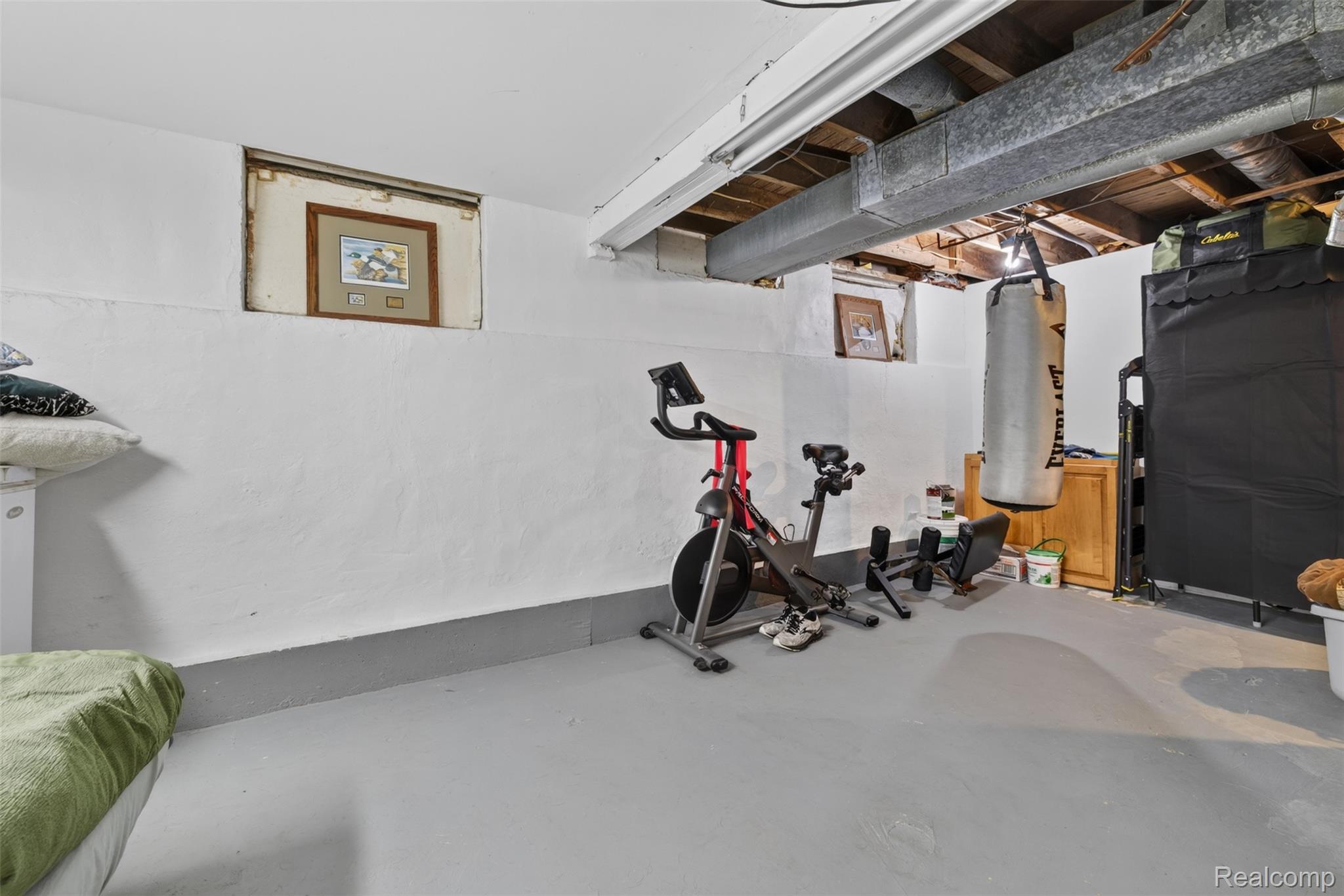 5244 Oleksyn Road Flint, MI 48504 - Photo 31 of 70 Spacious utility area featuring exposed ceiling joists and ductwork, painted concrete walls, and a painted concrete floor