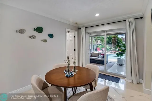 a dining room with furniture and a floor to ceiling window