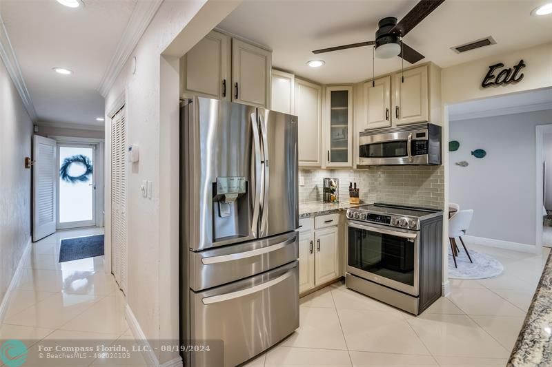 Undisclosed Address Pompano Beach, FL 33062 - Photo 17 of 63 a kitchen with stainless steel appliances granite countertop a refrigerator a stove and a sink