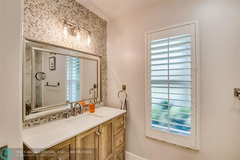 Undisclosed Address Pompano Beach, FL 33062 - Photo 32 of 63 a bathroom with a sink a vanity and a mirror